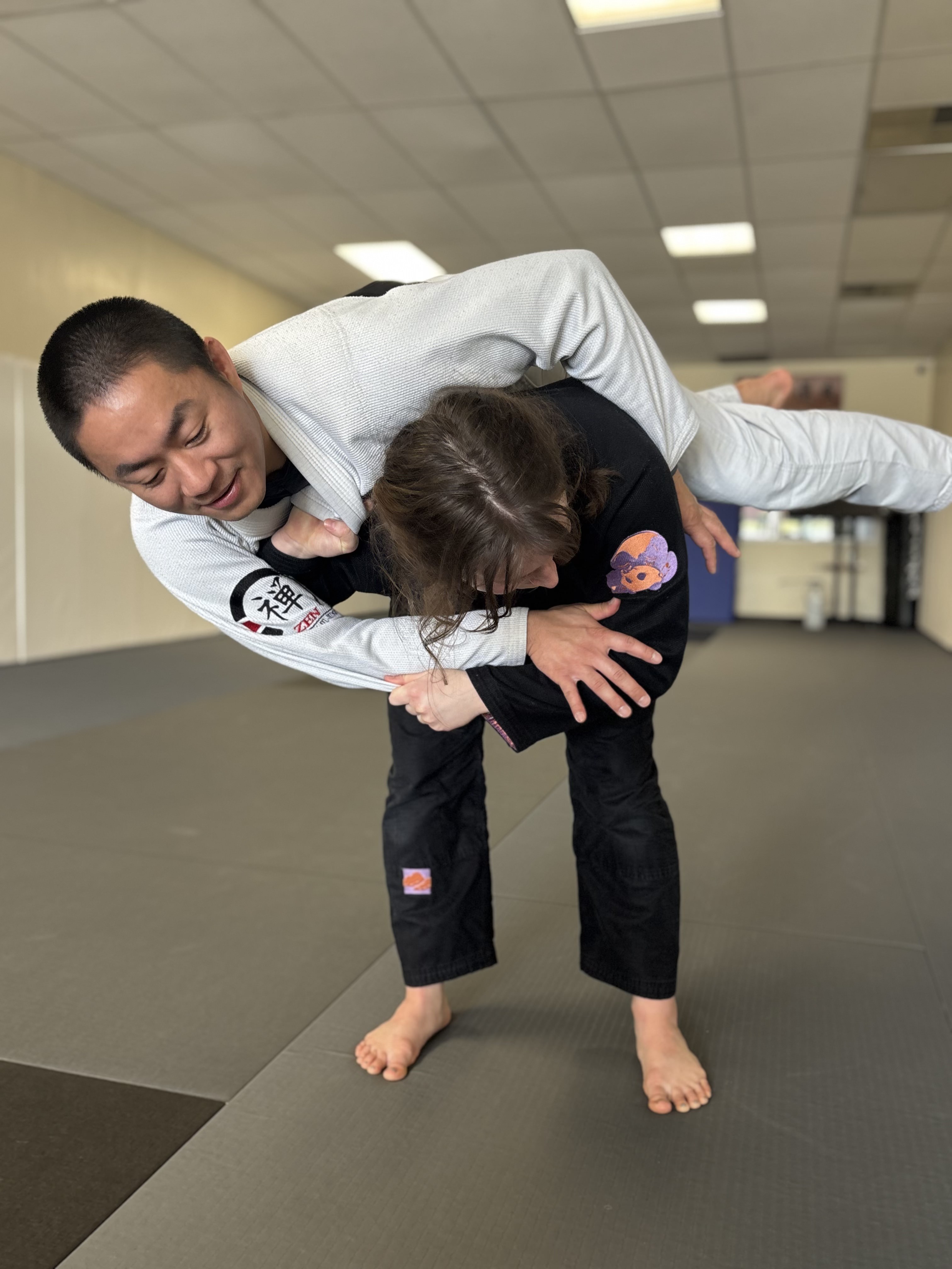 Instructor teaching a judo throw to a young student at ZEN Brazilian Jiu-Jitsu
